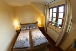 um pequeno quarto com uma cama e uma janela em Stary dum em Černošice