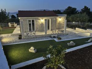 una pequeña casa con un patio con césped en Villa Maginja en Sutivan