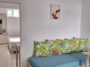 ein Wohnzimmer mit einem blauen Sofa und einem Kissen in der Unterkunft Le Beau Manguier Residence in Pereybere