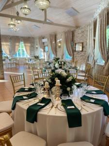 a table set up for a wedding with green napkins at Vila "Santa Barbara" in Toliejai