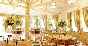 - une salle de banquet avec des tables, des chaises et des fleurs dans l'établissement Vila "Santa Barbara", à Toliejai