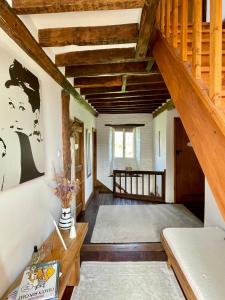 a living room with wooden ceilings and a staircase at La Paix, Chambre d'Hôte en Suisse Normande in Condé-sur-Noireau