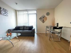 a living room with a couch and a table at 1 BED MODERN APARTMENT WITH FREE PARKING, SHEFFIELD CITY CENTRE in Sheffield