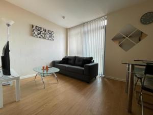 a living room with a couch and a table at 1 BED MODERN APARTMENT WITH FREE PARKING, SHEFFIELD CITY CENTRE in Sheffield