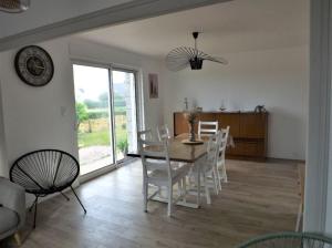 ein Esszimmer mit einem Tisch und weißen Stühlen in der Unterkunft Maison au calme in Erquy