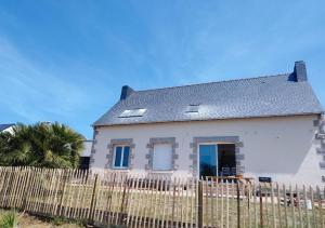 ein weißes Haus mit einem Zaun davor in der Unterkunft Maison au calme in Erquy