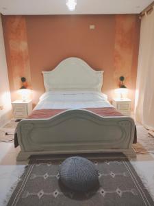 a large bed in a bedroom with two night stands at Dar Ranim Tozeur in Tozeur