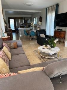a living room with two couches and a table at Villa avec piscine au soleil de la côte d’azur in Mouans-Sartoux