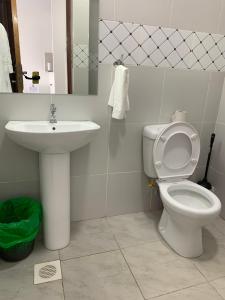 a bathroom with a toilet and a sink at COZY STUDIO apartment -The Aviv Place in Nairobi