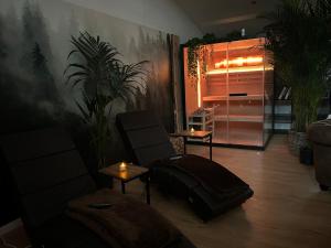 a living room with a chair and a suitcase at Wellness Suite mit Whirlpool und Sauna in Ahlen