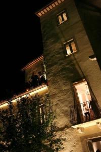 a building with two people on a balcony at night at Palazzo Bontadosi Hotel & Spa in Montefalco
