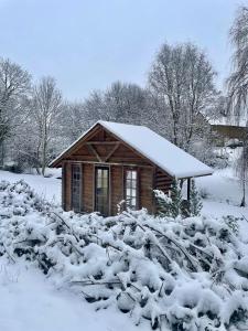 a small wooden cabin with snow on its roof at La Paix, Chambre d'Hôte en Suisse Normande in Condé-sur-Noireau