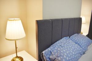 a bed with a blue headboard and a lamp on a table at Pleasant Room nearby edgbaston stadium in Birmingham