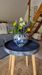 un jarrón azul y blanco con flores en una mesa en Albatross, en Dömös