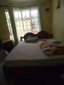 a bed with two pillows on it in front of a window at Stay with Daktari Homes in Homa Bay