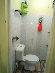 een badkamer met een toilet en een rode doek aan de muur bij Stay with Daktari Homes in Homa Bay