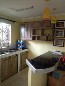 a kitchen with wooden cabinets and a black counter top at Stay with Daktari Homes in Homa Bay
