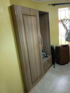 un gran armario de madera en una habitación con una maleta en Stay with Daktari Homes, en Homa Bay