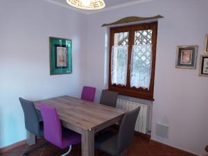 een eetkamer met een houten tafel en paarse stoelen bij Ferienwohnung für 2 Personen 3 Kinder ca 75 qm in Val Maria-pur, Trentino Ledrosee in Mezzolago