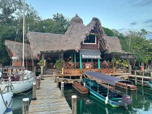 a boat is docked in front of a building on the water at Tortugal Boutique River Lodge in Rio Dulce