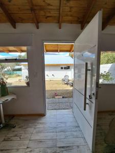 uma porta aberta para uma cozinha com um frigorífico em Apartamentos-Cabañas Encanto II em El Bolsón