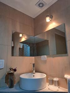a bathroom with a sink and a large mirror at Apartamentos-Cabañas Encanto II in El Bolsón