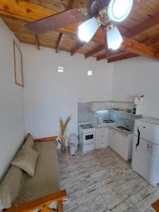 uma cozinha com um sofá e uma ventoinha de tecto em Apartamentos-Cabañas Encanto II em El Bolsón