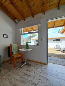 a living room with a table and a window at Apartamentos-Cabañas Encanto II in El Bolsón
