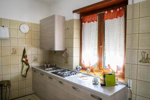 a kitchen with a stove and a sink and a window at Corno Grande - spacious apartment - 2 baths - Wi Fi- city center - free parking in LʼAquila +29 photos