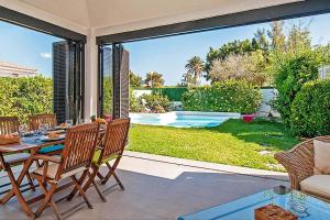 eine Terrasse mit einem Tisch, Stühlen und einem Pool in der Unterkunft Ferienhaus mit Privatpool für 4 Personen ca 125 m in Maspalomas, Gran Canaria Südküste Gran Canaria in Maspalomas