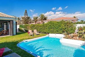 einen Pool in einem Garten mit zwei Gartenstühlen in der Unterkunft Ferienhaus mit Privatpool für 4 Personen ca 125 m in Maspalomas, Gran Canaria Südküste Gran Canaria in Maspalomas
