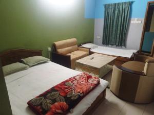 a room with a bed and a chair in a room at Hotel Asia in Cox's Bazar