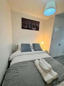 a bedroom with a large bed with towels on it at Luxury rooms in Bow in London