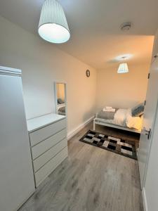 a small bedroom with a bed and a mirror at Luxury rooms in Bow in London