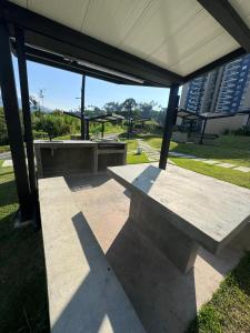a concrete bench sitting under a pavilion in a park at Luxurious With Private Jacuzzi 3-Bedroom Apartment in Pereira in San Joaquín