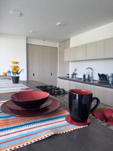 a kitchen with plates and a coffee cup on a counter at Luxurious With Private Jacuzzi 3-Bedroom Apartment in Pereira in San Joaquín