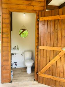 La salle de bains est pourvue de toilettes et d'une porte en bois. dans l'établissement Villa Créole idéalement située, au Lamentin