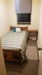 Un dormitorio con una cama y un televisor de pantalla plana. en Los Quillayes, en Los Ángeles