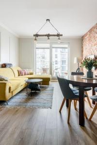 un soggiorno con divano giallo e tavolo di Gdańsk Apartment with Sunny Balcony a Danzica