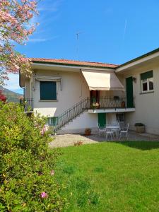 a house with a patio and a grass yard at Casa Tina in Verbania