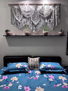 a bedroom with a bed with blue sheets and flowers at Anavrin Art House in New Delhi