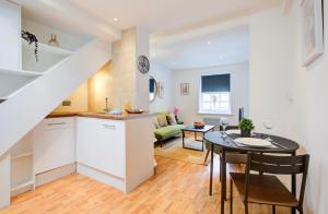 a kitchen and a dining room with a table in a room at Elegant 1 Bedroom Flat in Brentwood