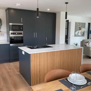 a kitchen with black cabinets and a table and a dining room at Sea Breeze in Wexford