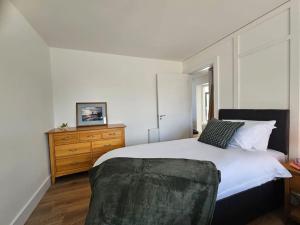 a bedroom with a bed and a wooden dresser at Sea Breeze in Wexford
