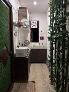a kitchen with a sink and a counter with a clock at Anavrin Art House in New Delhi