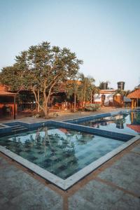 a large swimming pool in a courtyard with trees at La Triada in Ríohacha