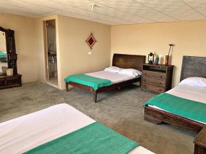 a bedroom with two beds and a dresser in it at La Triada in Ríohacha