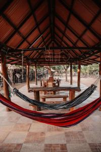 a hammock in a pavilion with a table and benches at La Triada in Ríohacha