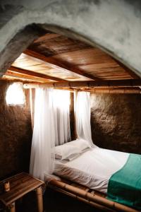 Ce lit se trouve dans un dortoir doté d'un plafond en bois. dans l'établissement La Triada, à Ríohacha