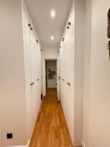 un corridoio con armadi bianchi e pavimento in legno di Le Clara Chic - 1 Chambre - Balcon - 4 Personnes - Cosy a Boulogne-Billancourt